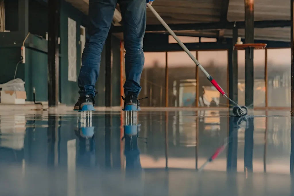 applying-epoxy-floor-coating-inside-building-eurocruitment