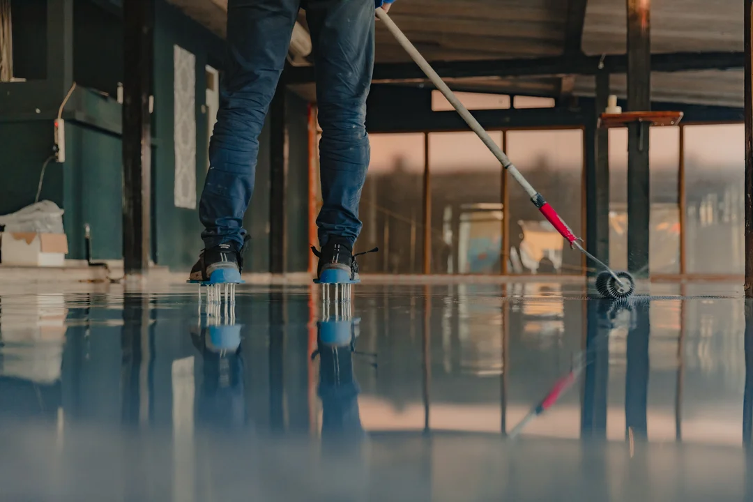 applying-epoxy-floor-coating-inside-building-eurocruitment