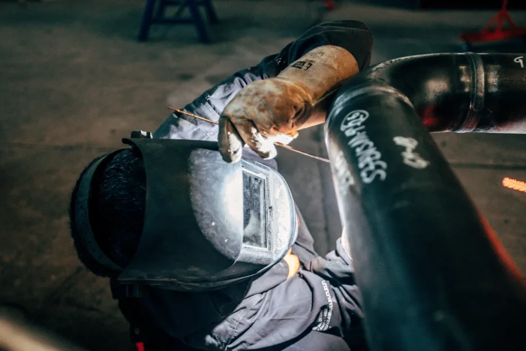 worker-with-protective-equipment-welding-pipe-eurocruitment