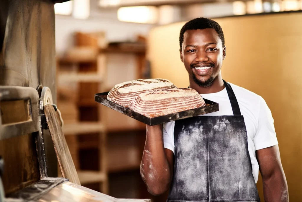 smiling-baker-holding-fresh-baked-bread-eurocruitment