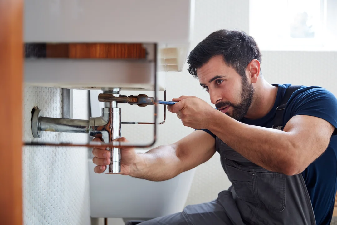 man-repairs-a-sink-drain-with-wrench-eurocruitment